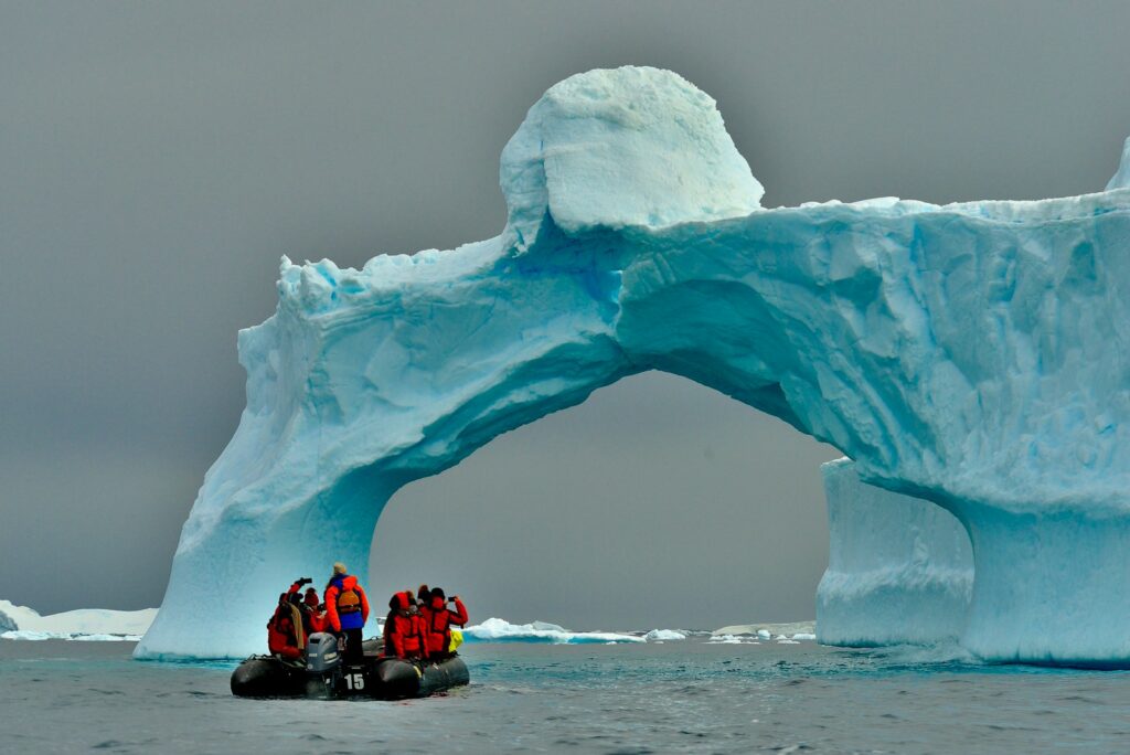 people sitting on ice formation during daytime